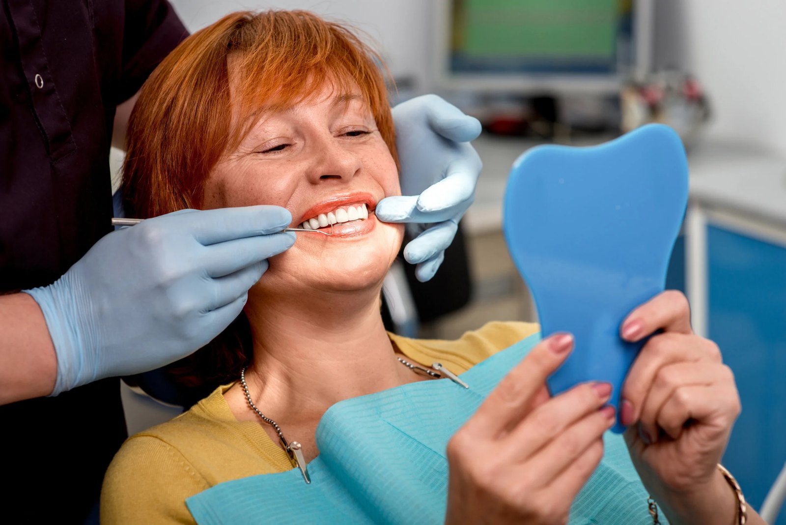 An adult looking in a mirror during a dental check